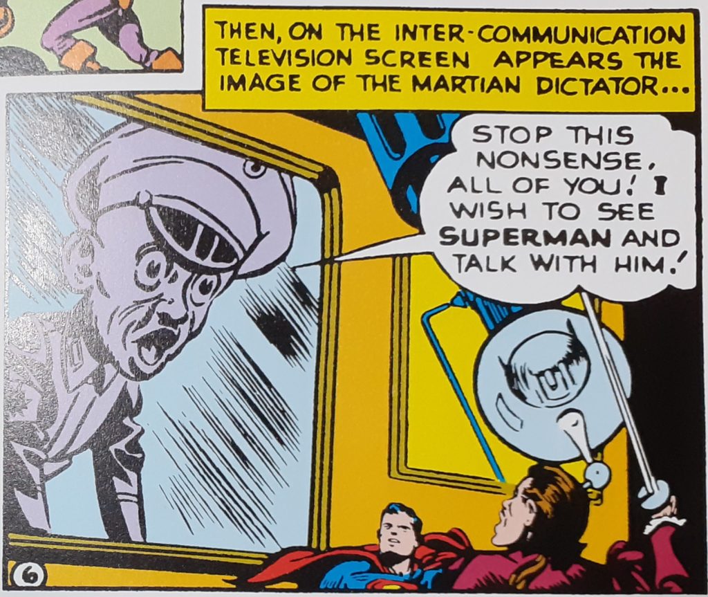A comic panel with Superman and Orson Welles looking up at a television screen showing the Martian Leader dressed in a military uniform. He's saying: "Stop this nonsense, all of you! I wish to see Superman and talk with him!".