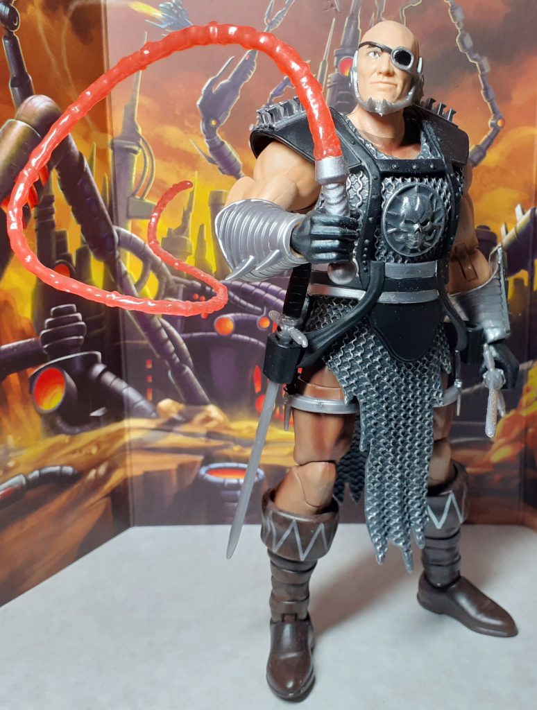 A figure based on the Blade character from the 1987 Masters of the Universe movie. The figure is wearing a suit of silver and black chain mail armour. Its also holding a red energy whip towards the viewer.