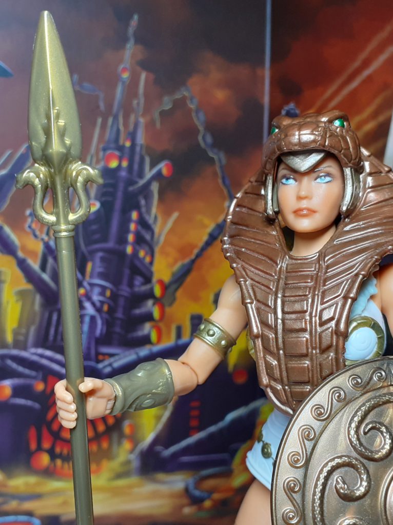 In this photo the New Eternia Teela is holding its spear. The spear is again moulded in the bronze plastic and has small snake designs worked into the spear head.