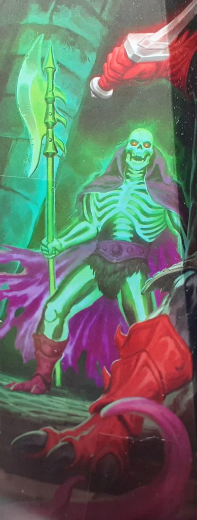 Part of the box art for the Ninjor figure. Behind Ninjor, Scare Glow can be seen. Scare Glow has glowing green bones, a long purple cape which is ragged along the bottom edge and is holding a halberd in his right hand. The halberd also looks like it is glowing and has a large blade at the top.