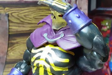 The Revelation Scare Glow figure posed looking over to the viewer's left. Its left open hand is posed over its eyes and shading them as though the figure is looking for something in the distance.