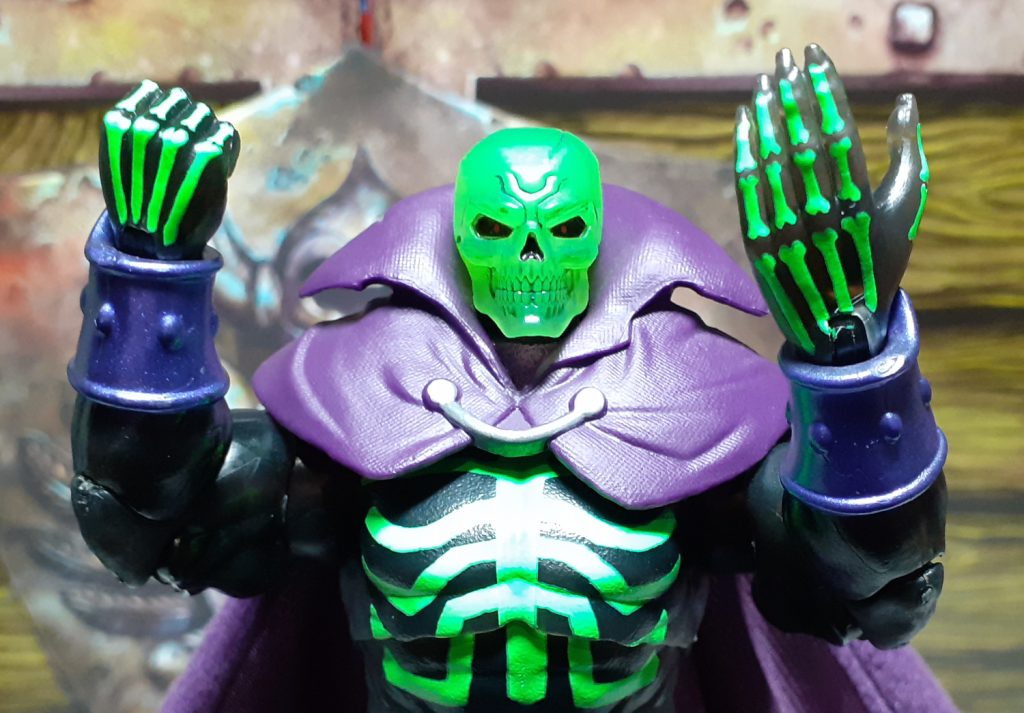 The SDCC Scare Glow figure holding up the other pair of hands the figure comes with. The right hand is in a fist while the left hand is open and flat. Again these hands have bones painted on them.