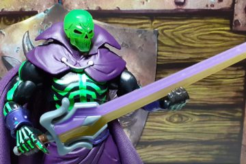 The SDCC Scare Glow holding the Sword of Power in its right hand and gripping the blade in its left. This version of the Sword has a large oversized hilt section and a blade that's split into two halves - one half is a translucent purple and the other is a light yellow in colour.