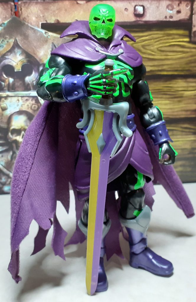 Scare Glow standing, facing the viewer and holding the Sword of Power point downwards with the very tip of the sword resting on the ground.