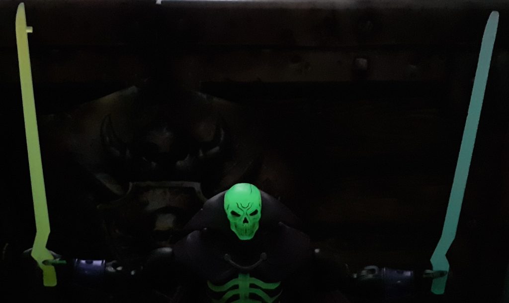 Another photos of the two halves of the Sword of Power glowing in the dark. Scare Glow is posed holding them apart with the blades pointing straight up.