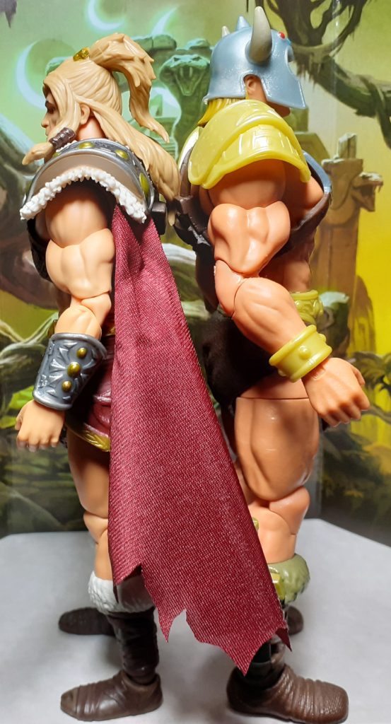 The King Grayskull and Viking He-Man figures standing back to back. In this photo, the King Grayskull figure has had its hip joints extended so that it stands a bit taller. It still isn't quite as tall as the Viking He-Man figure though.