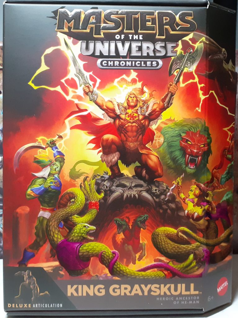 The front of the box for King Grayskull. At the top in embossed text it reads "Masters of the Universe Chronicles". At the bottom is the figure's name "King Grayskull". In between the text is a painted scene of King Grayskull crouching down while holding up his Sword and battle axe. Below him are some Snake Men characters and behind him is Battle Lion, a green lion with a red face mask.