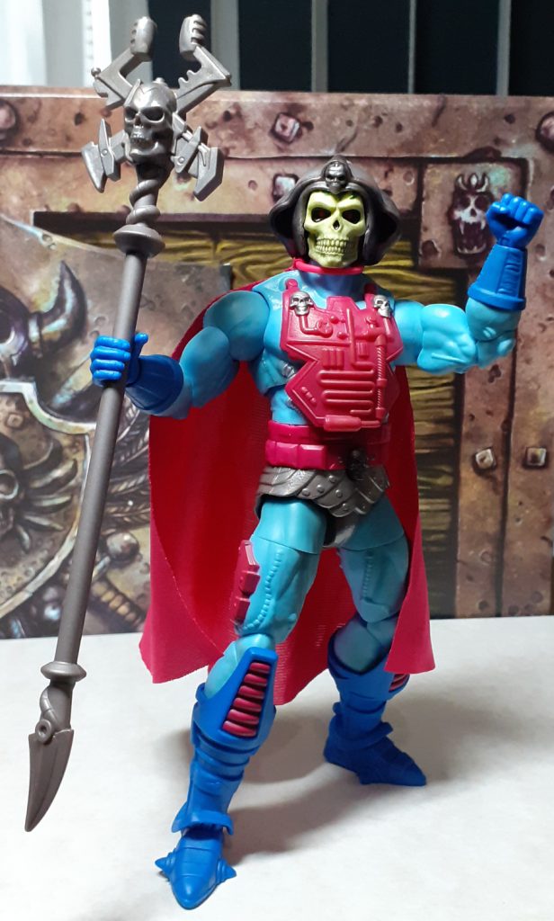 The New Adventures Skeletor figure posed with it's left arm up in air and holding the Havoc Staff in its right. This version of Skeletor has lots of cybernetic and armour implants giving it a different look. However it still has the light blue skin and yellow skull face of the traditional Skeletor.