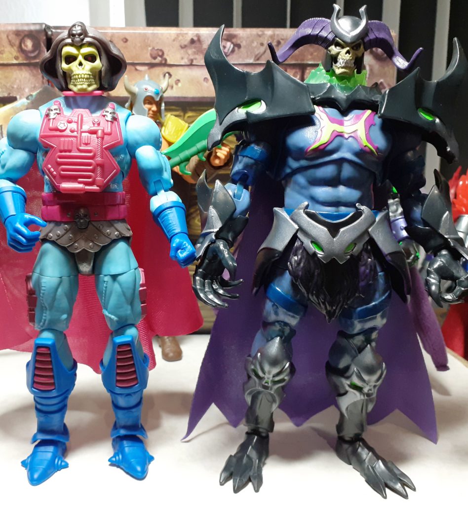 Another height comparison photo. In this one the New Adventures Skeletor figure is joined with on the right, the Skelegod figure. This latter figure is slightly taller but much broader than the Skeletor figure.