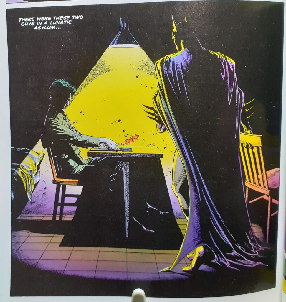 One of the panels from the scene where Batman enters the Joker's prison cell and joins him at a small table. This is from the DC Finest Batman The Killing Joke and Other Stories book. The colouring is rather more garish and has a bright yellow beam of light coming down from a lamp positioned over the table.